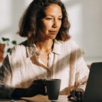 Profissional usando notebook com painéis de dados e interface digital, para o artigo Como fazer renda extra na internet: G...