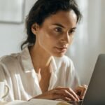Pessoa analisando gráficos financeiros em celular e notebook, para o artigo Fonte de renda extra: 50 ideias práticas para ...
