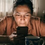 Pessoa analisando gráficos financeiros em celular e notebook, para o artigo PIX EMPRESTADO: Como Conseguir até R$1500 Apro...