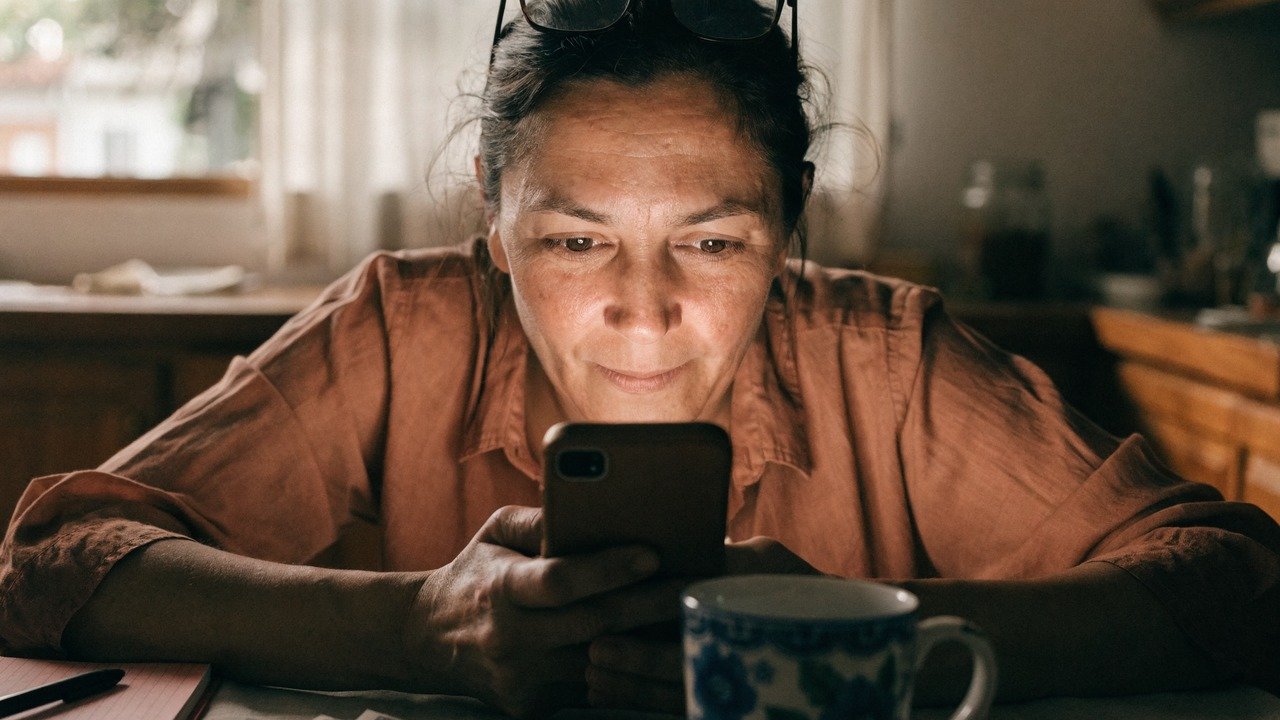Pessoa analisando gráficos financeiros em celular e notebook, para o artigo PIX EMPRESTADO: Como Conseguir até R$1500 Apro...