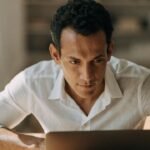 Profissional usando notebook com painéis de dados e interface digital, para o artigo Portal do Empreendedor: Guia Completo...