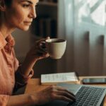 Pessoa analisando gráficos financeiros em celular e notebook, para o artigo Renda extra em casa: 50 ideias práticas e segu...