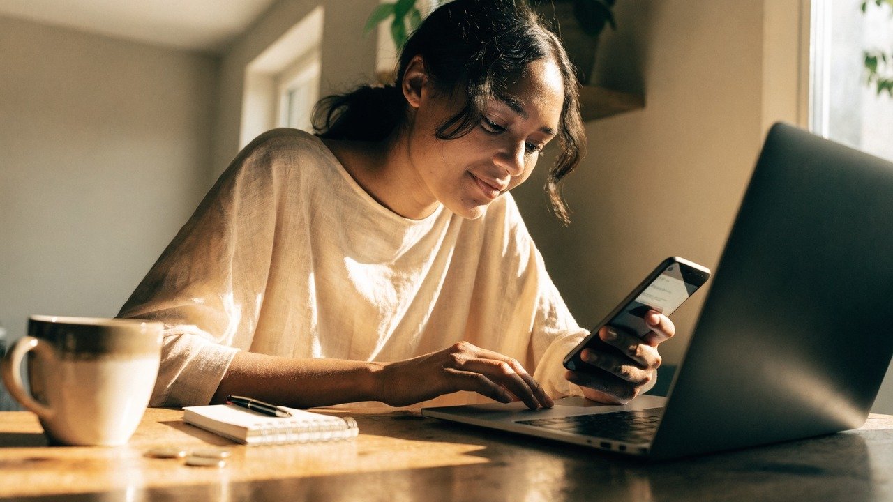 Pessoa analisando gráficos financeiros em celular e notebook, para o artigo Renda Extra Fácil: Guia Prático para Começar a...