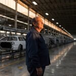 Profissional usando notebook com painéis de dados e interface digital, para o artigo Toyota fecha fábrica de Indaiatuba: O...