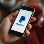 Pessoa brasileira trabalhando em ambiente digital profissional para ilustrar Como Ganhar Dinheiro com PayPal Pelo Celular, com mesa.