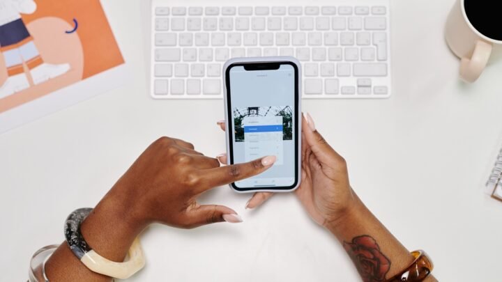 Pessoa analisando gráficos financeiros em celular e notebook, para o artigo como cancelar uma autorização de Pix Automátic...