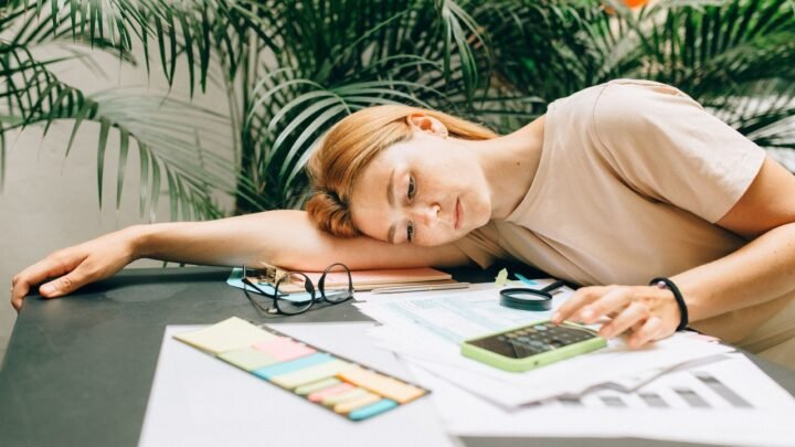 Pessoa analisando gráficos financeiros em celular e notebook, para o artigo Empresa descontou empréstimo consignado do sal...