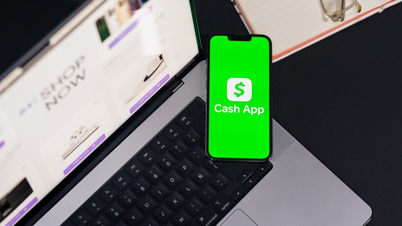 Pessoa analisando investimentos no app do Nubank, com notebook aberto, para o artigo Nubank avalia compra do banco digital...