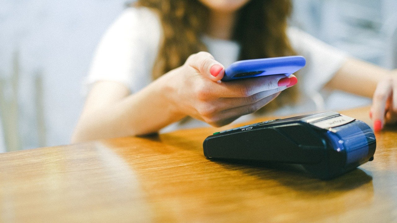 Pessoa analisando gráficos financeiros em celular e notebook, para o artigo Pix Automático sem saldo pode usar cheque espe...