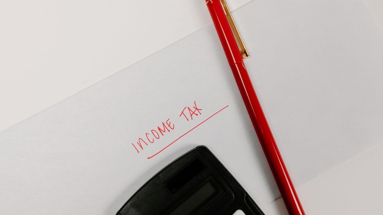 Profissional usando notebook com painéis de dados e interface digital, para o artigo Impostos Sobre Renda Extra em 2026: C...