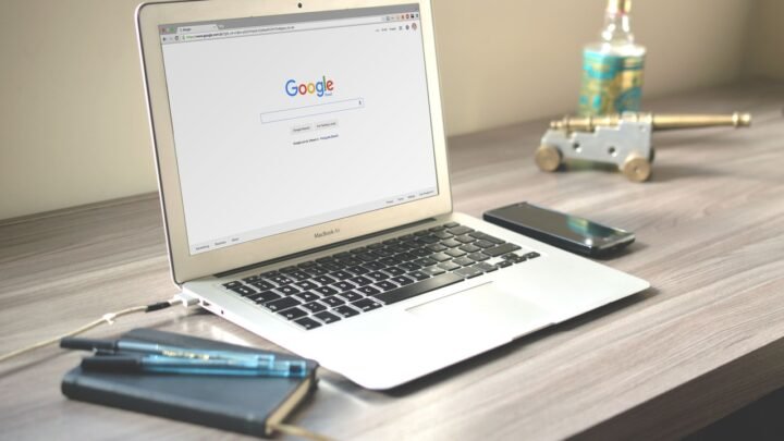 Pessoa analisando gráficos financeiros em celular e notebook, para o artigo Pesquisas Remuneradas Online: Melhores Platafo...