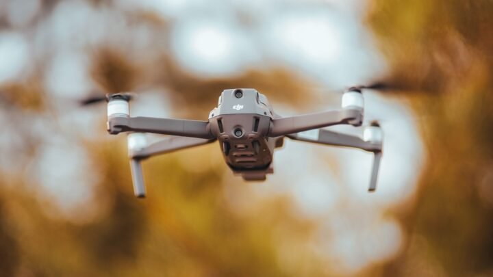 Profissional usando notebook com painéis de dados e interface digital, para o artigo Piloto de drone freelancer no agro: c...