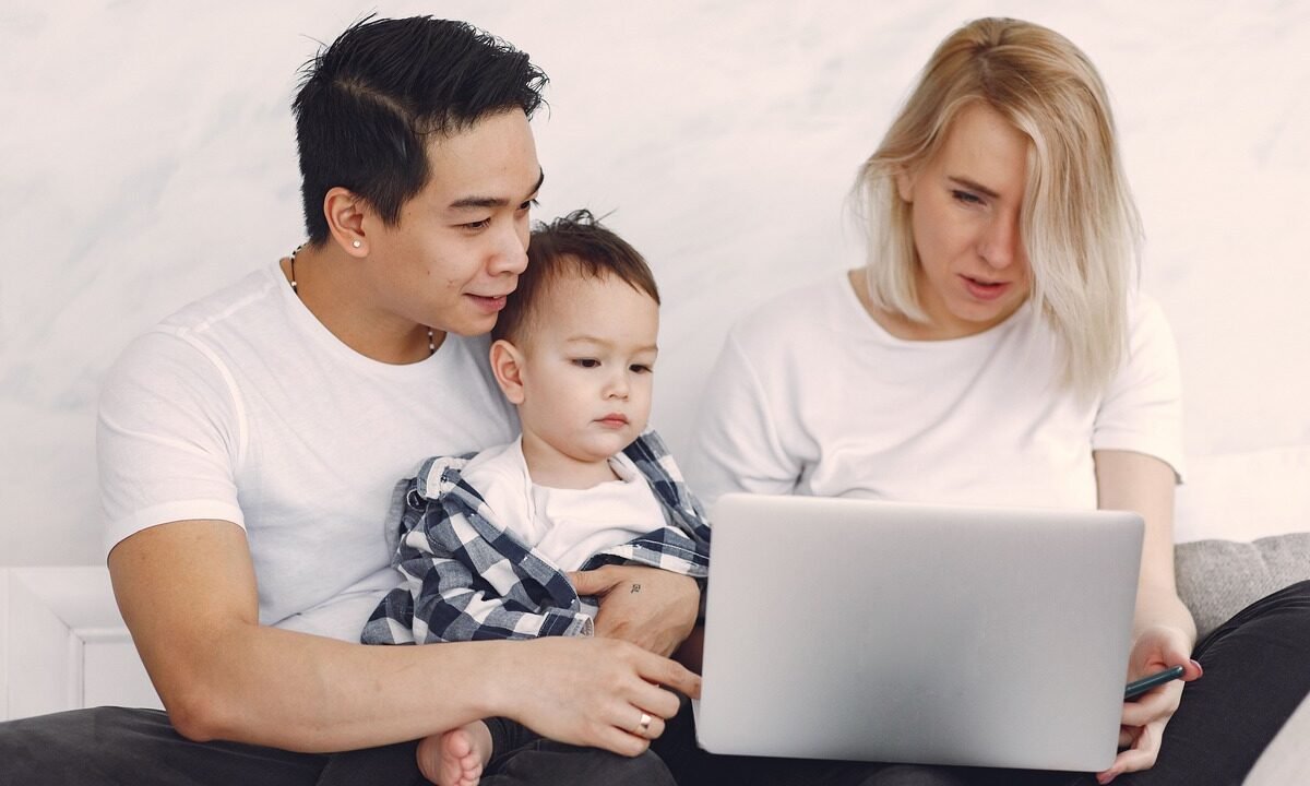 Pessoa analisando gráficos financeiros em celular e notebook, para o artigo Renda Extra em Família: 5 Ideias Práticas Para...