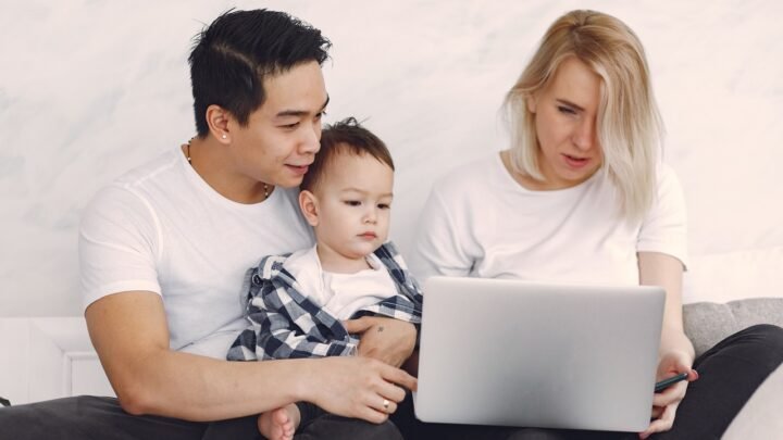 Pessoa analisando gráficos financeiros em celular e notebook, para o artigo Renda Extra em Família: 5 Ideias Práticas Para...